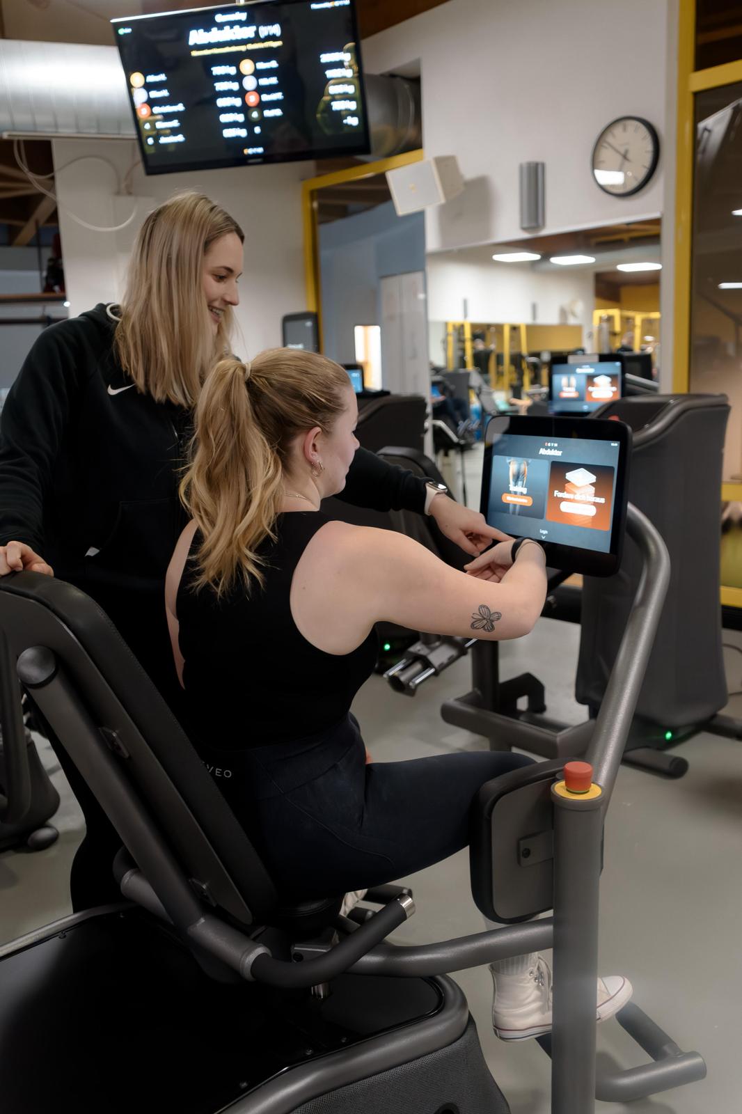 Trainerin erklärt eGym-Einweisung
